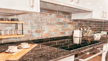 Een koelkast, een oven, een kookplaat, een koffiezetapparaat/waterkoker