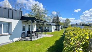Une rangée de bâtiments modernes, blancs, dotés de toits plats et de grandes fenêtres, qui font probablement partie d’un hôtel ou d’un complexe touristique.