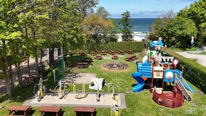 A playground with slides and climbing structures, picnic tables, and exercise equipment. - Holiday home very close to the beach (Sianozety)