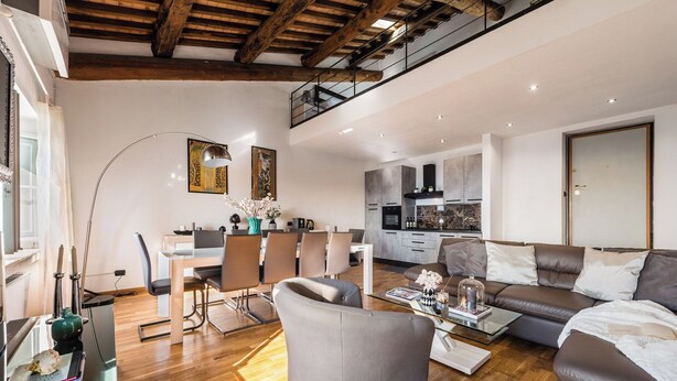Una sala de estar moderna con comedor, cocina y un altillo.