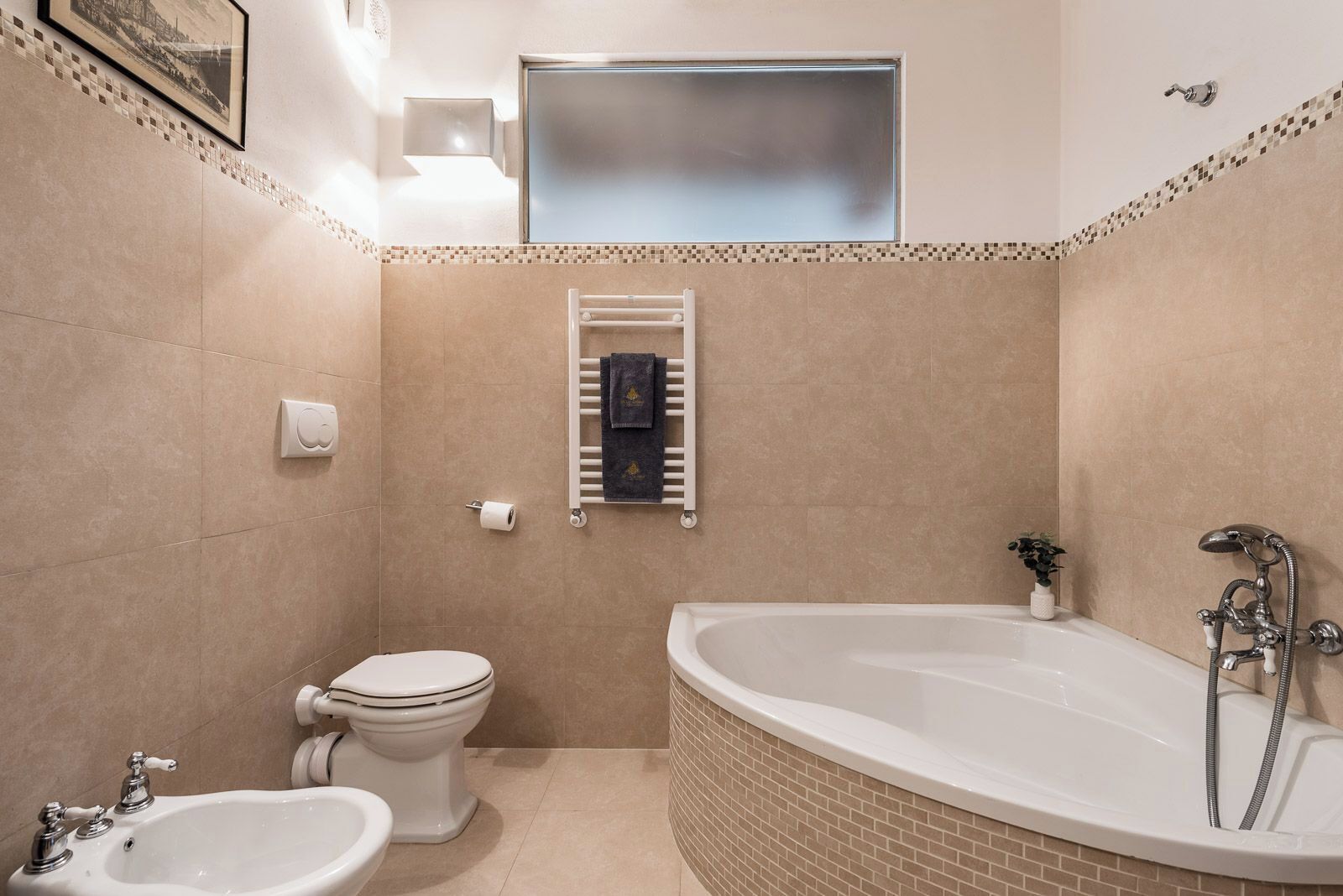 A bathroom with a toilet, bidet, and bathtub.