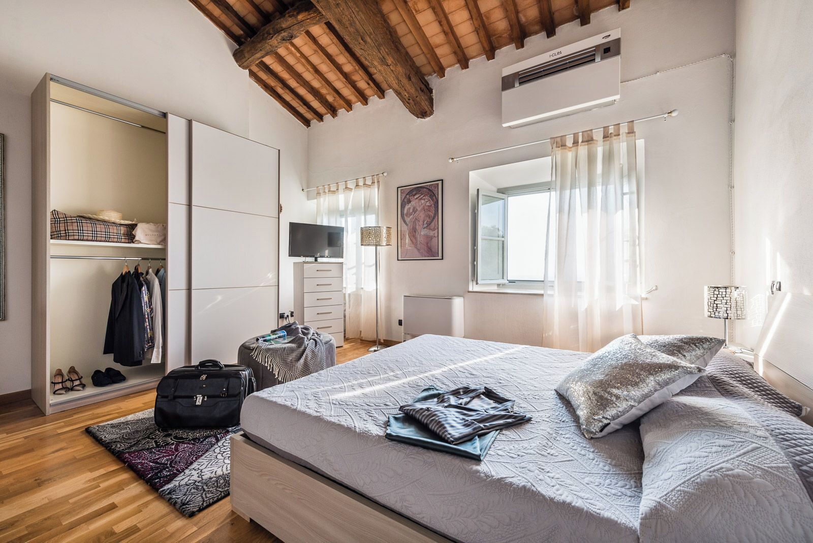 Ein Schlafzimmer mit Bett, Schrank und Schreibtisch mit Stuhl.