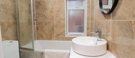 A bathroom with a bathtub, a sink, and a toilet.