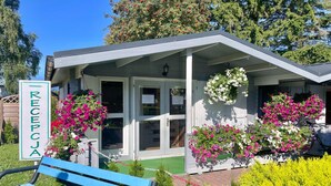 A reception area with a sign, a bench, and flower boxes. - Comfortable holiday homes, right by the beach (Sianozety)