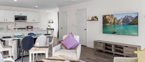 Un espacio habitable moderno con cocina, comedor y un amplio ventanal con vistas a la montaña.