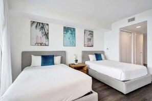 A hotel room with two beds, a small table, and artwork on the wall. - Ocean and Canal View Condo Resort Hallandale 706 (Hallandale Beach)