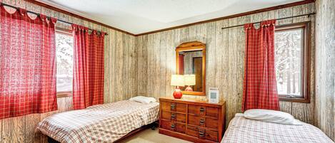 Un dormitorio con dos camas, un aparador y un espejo.
