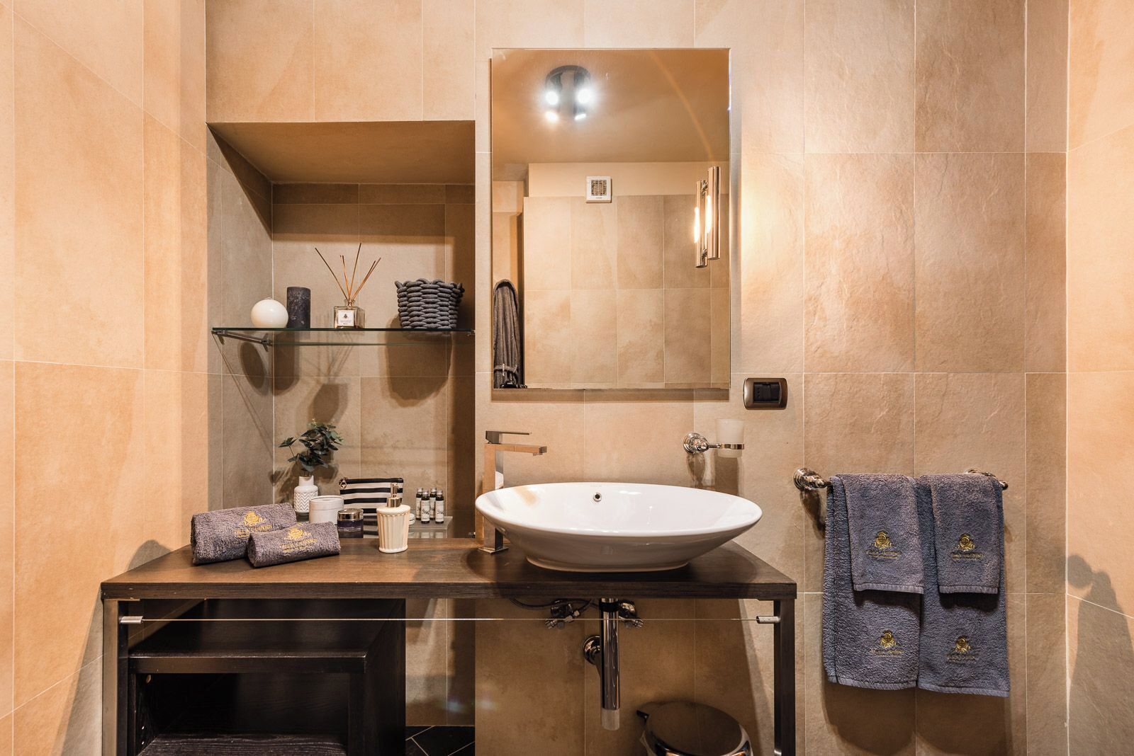 Une salle de bain moderne avec un grand lavabo, un miroir et un porte-serviettes.