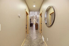 A hallway with wooden doors, a mirror, and a ceiling fan. - Elevated Luxury 4-bedroom cabin in Devils Lake with Fishing Access (Warwick)