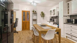 Eine moderne Küche mit weißen Schränken, einem Holztisch und einem eingebauten Backofen.