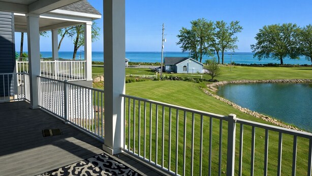A covered porch with a view of a golf course and a body of water. - Perfect 3-bedroom house with AC in soothing Waterview @ Baypoint (Lakeside Marblehead)