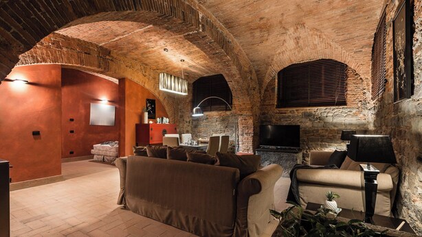 A cozy living room with a brick ceiling, a fireplace, and comfortable seating. - Loft with Stone vaults in Villa Storica (Matraia)