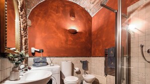 A bathroom with a washing machine, a toilet, a bidet, and a shower. - Loft with Stone vaults in Villa Storica (Matraia)
