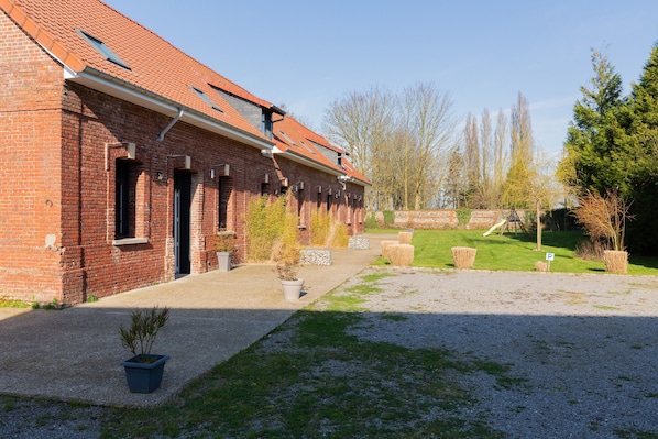 Ein Backsteinhaus mit mehreren Fenstern und einem überdachten Gang.