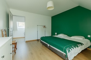 Une chambre à coucher avec un lit, un bureau, une chaise, une armoire et une fenêtre.