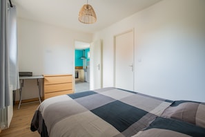 Une chambre à coucher avec un lit, un bureau et une armoire.