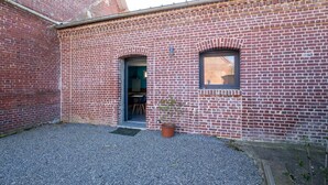 Ein Backsteinhaus mit zwei Türen und einem kleinen Fenster.