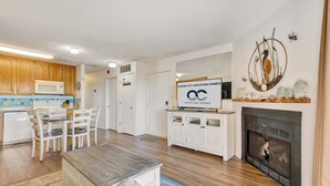 Une cuisine moderne avec des meubles en bois, un four à micro-ondes et un coin repas comprenant une table et des chaises.