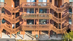 Un immeuble à plusieurs étages, doté d’une façade en bois et de nombreux balcons.