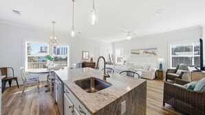 Amplia sala de estar con isla de cocina, mesa de comedor y asientos.