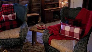 Ein gemütliches Zimmer mit Holzwänden, einem Fernseher, einem Bücherregal und Lichterketten.