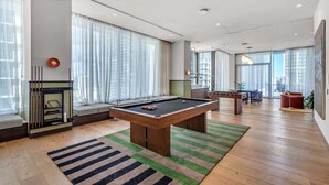 Una sala de estar moderna con mesa de billar, sofá y chimenea.