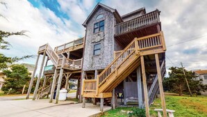 A multi-level wooden structure with external staircases and balconies, surrounded by greenery. - Cozy Oceanside 3-bedroom house in fabulous Avon with incredible ocean views. (Avon)