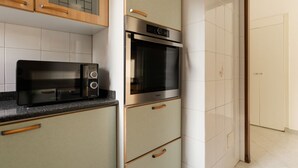 A kitchen with a microwave, oven, and cabinets. - GuestHost - Cozy 56 sqm apartment, located on the second floor of a building without an elevator.The accommodation is located in the San Siro area, an ideal neighbourhood for those looking for a quieter alternative to the city centre without giving up co (Milan)