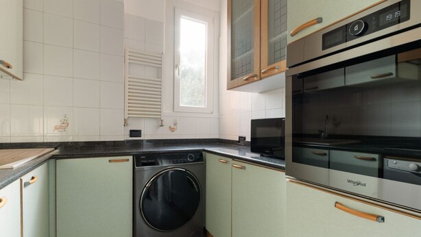 A kitchen with a washing machine, an oven, and a window. - GuestHost - Cozy 56 sqm apartment, located on the second floor of a building without an elevator.The accommodation is located in the San Siro area, an ideal neighbourhood for those looking for a quieter alternative to the city centre without giving up co (Milan)