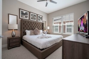 Ein Schlafzimmer mit einem großen Bett, einem Fernseher und einem Fenster mit Jalousien.