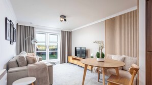 A modern living room with a sofa, a round wooden table, and a TV. - Old Prestwick Point (Prestwick)