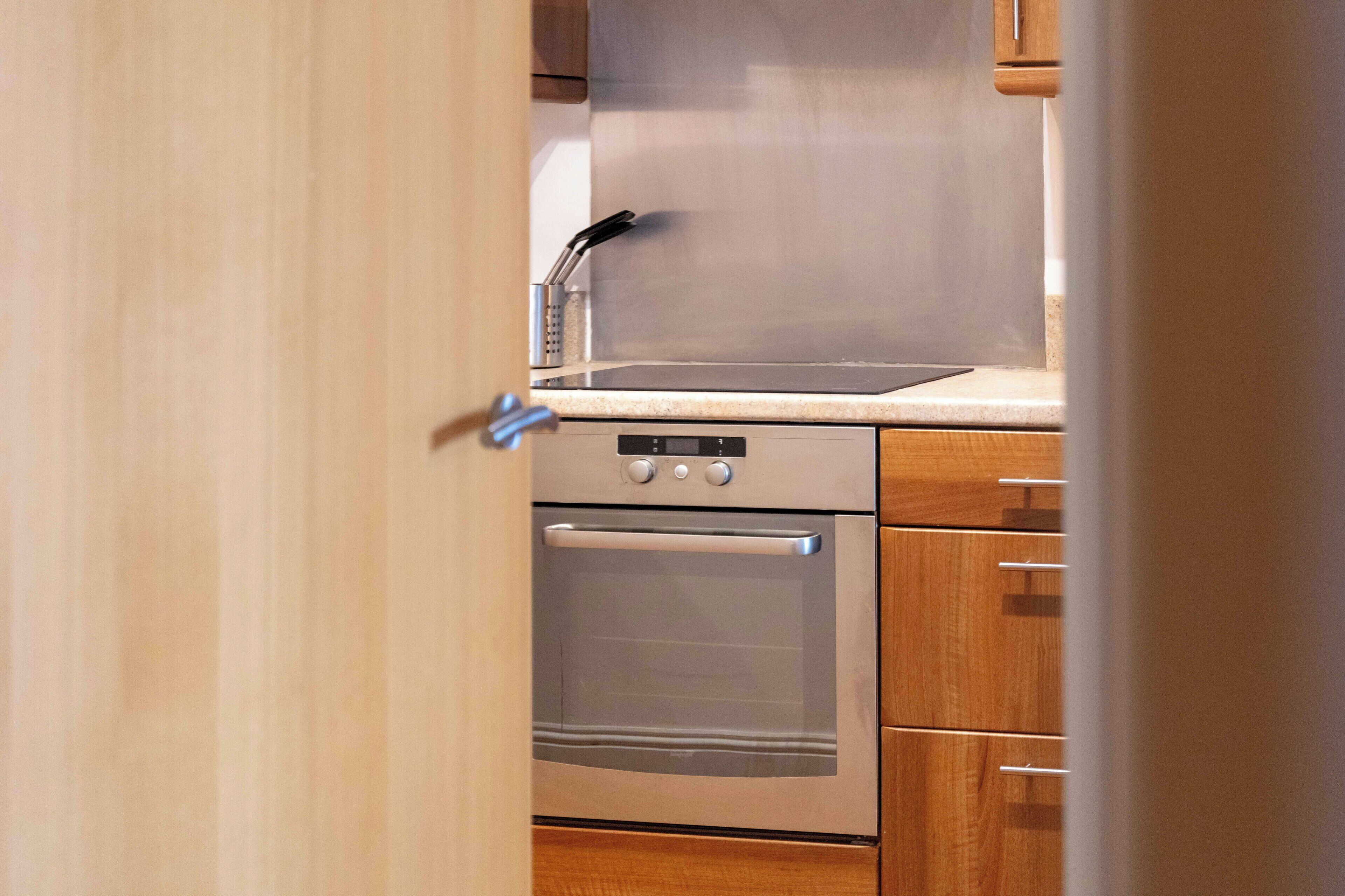 A kitchen with a stainless steel oven and a microwave on the countertop.
