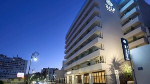 Un hotel de varios pisos con un letrero llamativo que dice "RALE HOTEL".