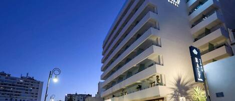Un hotel de varios pisos con un letrero llamativo que dice "RALE HOTEL".