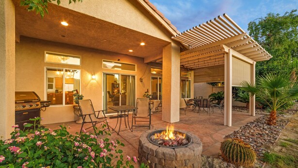 An outdoor patio with a fire pit, seating, and a grill area. - Golf-View Home | Indian Palms Resort Pool & Patio (Indio)