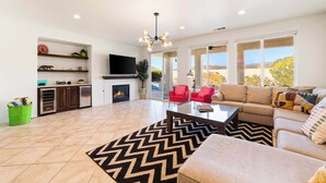 Un salón espacioso con chimenea, televisor y un ventanal que ofrece vistas al exterior.