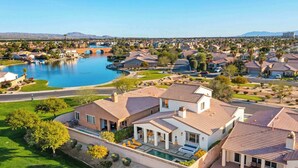 Zona residencial con casas, piscina y un puente sobre el agua.