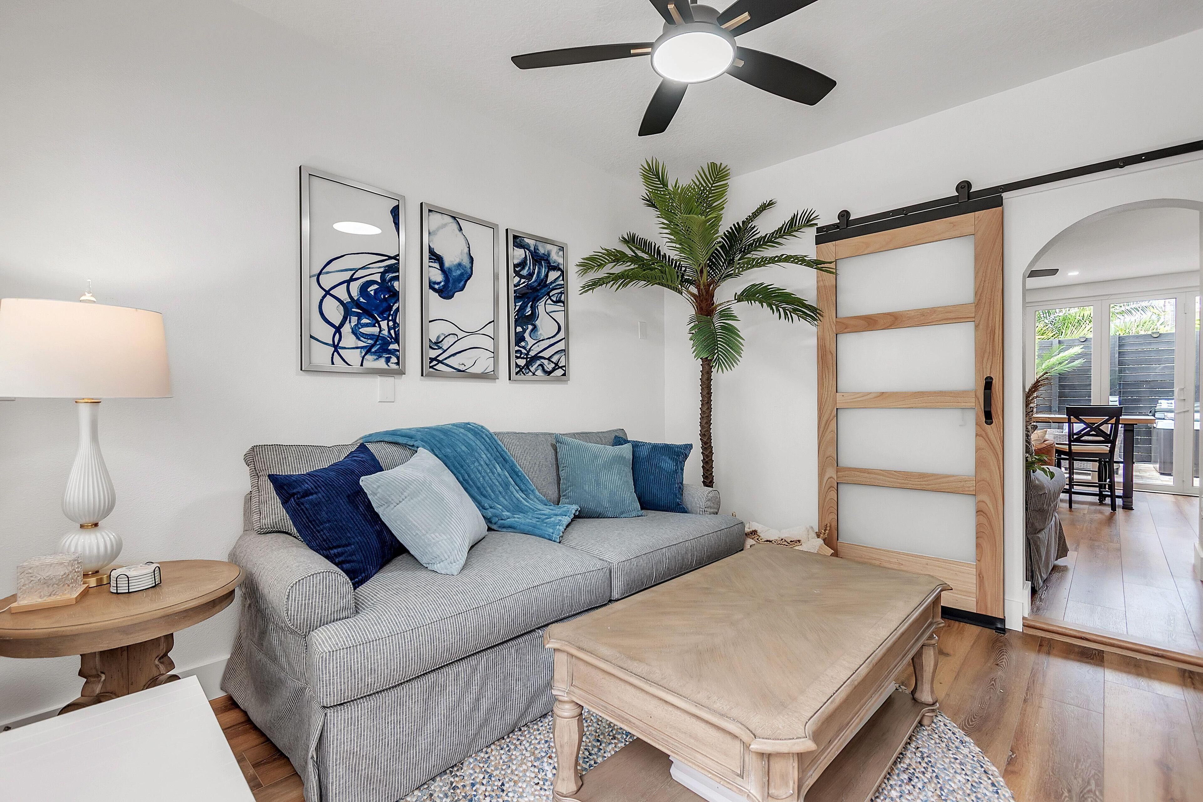 A modern living room with a sofa, coffee table, and a sliding barn door.