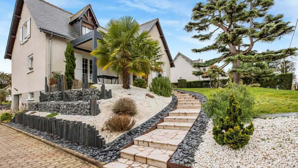 A modern house with a stone pathway leading to the entrance, surrounded by well-maintained gardens and a large tree. - Guest Room - Mon Plaisir (Civray-de-Touraine)