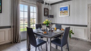 A dining area with a table set for breakfast, a vase with flowers, and a view of the outdoors. - Guest Room - Mon Plaisir (Civray-de-Touraine)