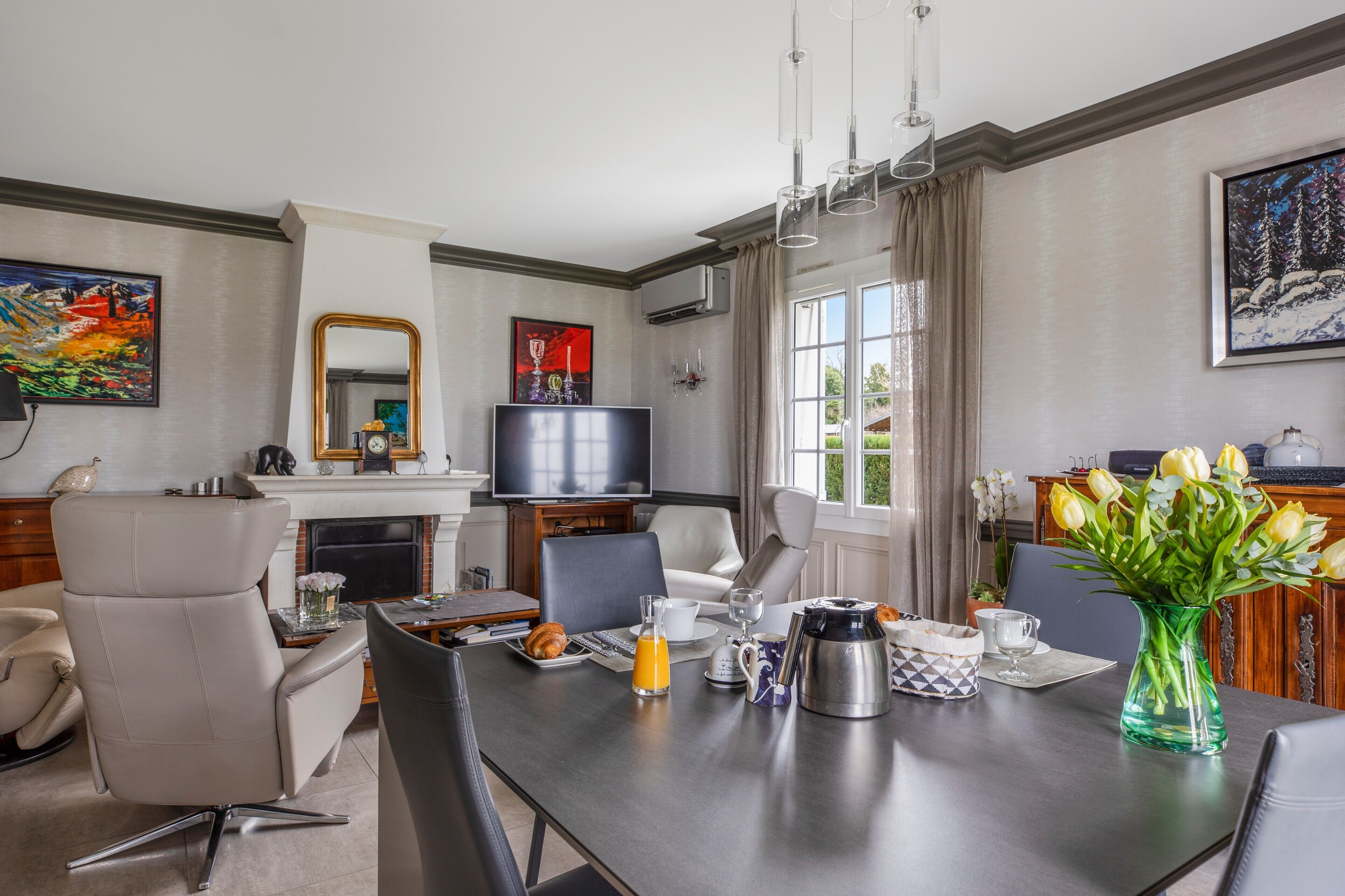Een moderne hotelkamer met een eethoek, een televisie en een open haard.