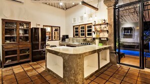 Una cocina amplia con una isla central, armarios de madera y un gran ventanal corredero que da a un área exterior.