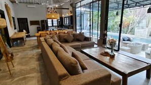 Amplia sala de estar con un sofá grande, una mesa de centro y vistas a una piscina.
