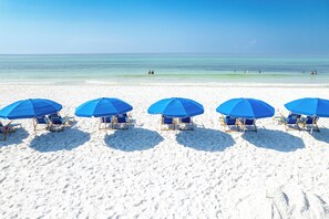 A beach with five blue umbrellas and beach chairs aligned in a row. - Stunning Gulf Front Studio w/ Beach Service for 2, Islander Beach Resort 404 (Fort Walton Beach)