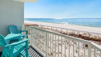A balcony with a view of a beach and ocean.