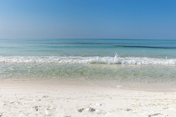 A beach with clear turquoise water and white sand.