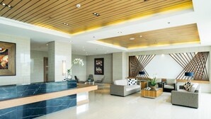 A modern lobby with a marble reception desk, seating area with sofas and armchairs, and decorative wall panels. - WIND TAAL TAGAYTAY PHILIPPINES (Tagaytay City)