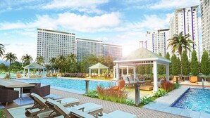 A resort with a swimming pool, lounge chairs, and a gazebo. - WIND TAAL TAGAYTAY PHILIPPINES (Tagaytay City)