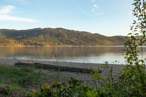 A calm lake with a forested hill in the background.