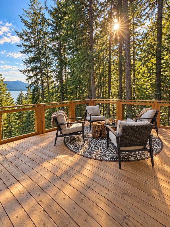 A deck with a round table, four chairs, and a wooden railing.